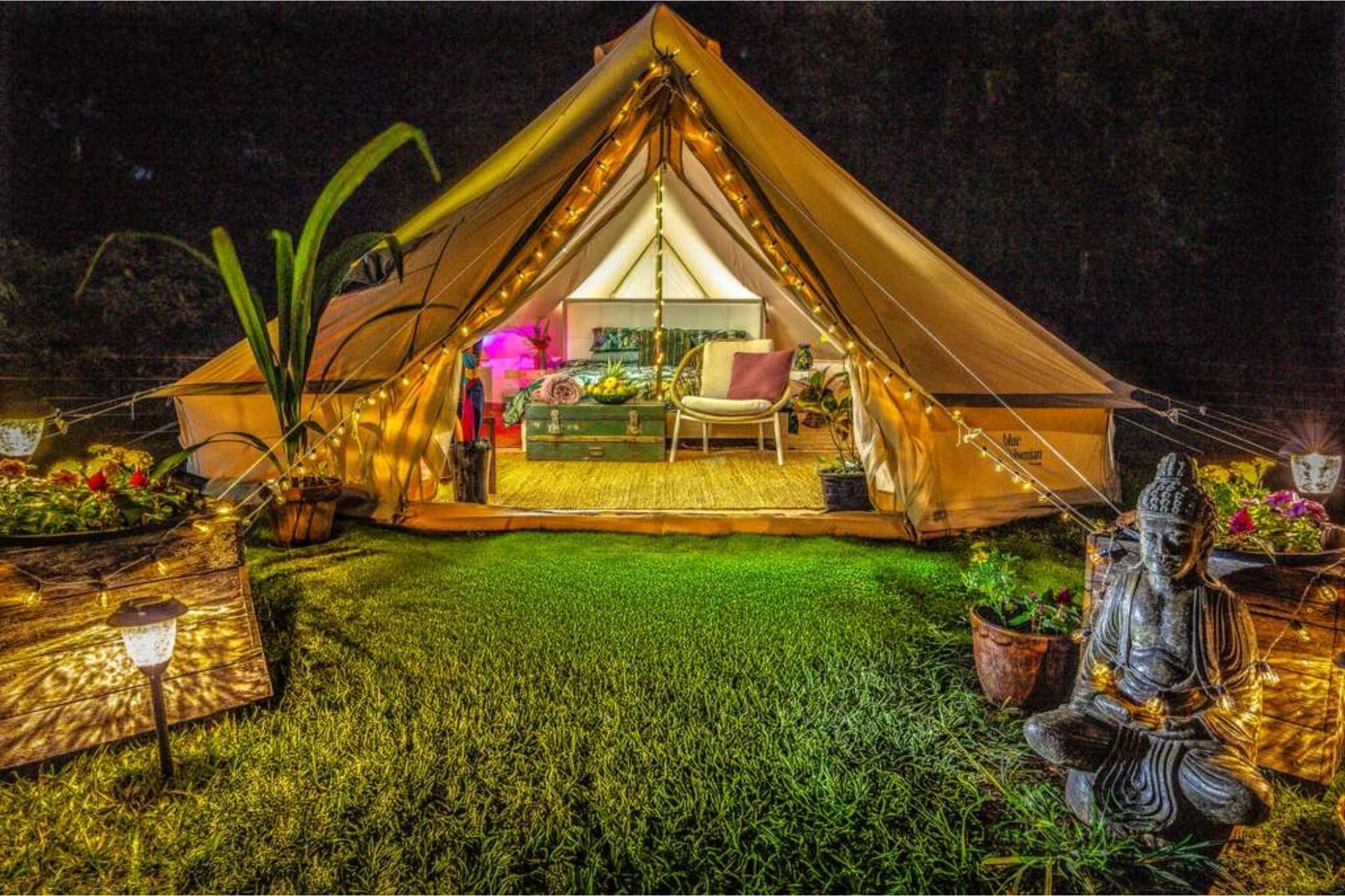 6m glamping bell tent exterior at night with warm lights, open entrance, and cozy outdoor setup